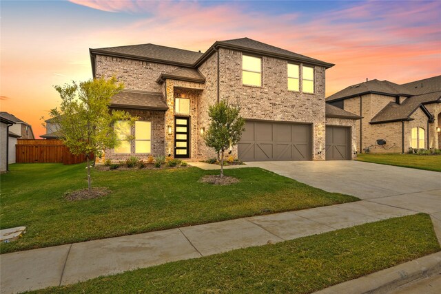 view of front facade with a yard and a garage