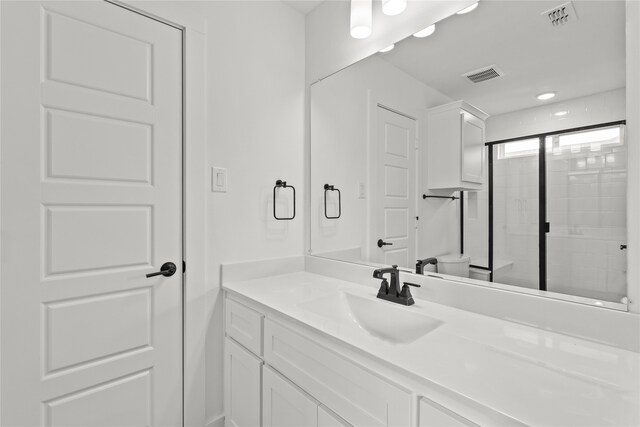 bathroom featuring vanity, toilet, and an enclosed shower