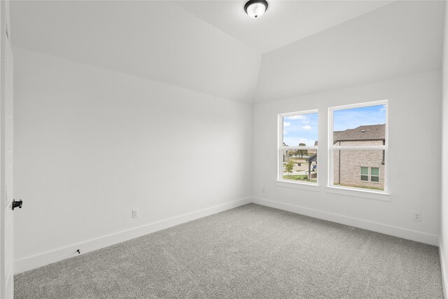 spare room featuring lofted ceiling and carpet floors