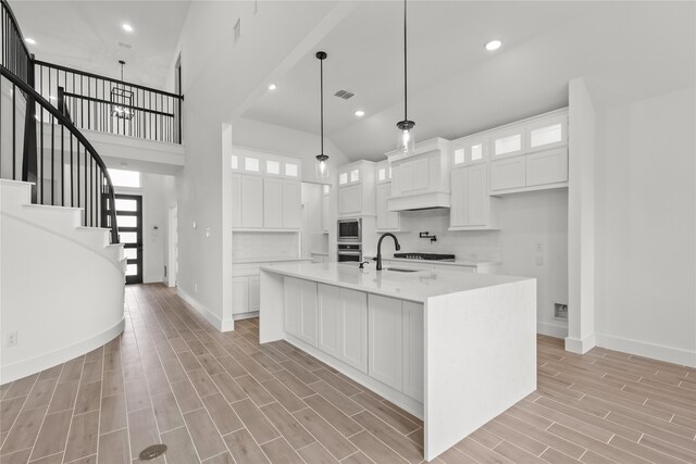 kitchen featuring white cabinetry, light hardwood / wood-style floors, and a center island with sink