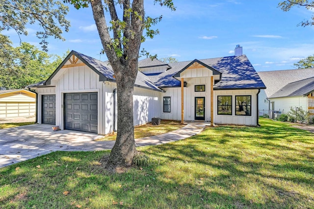 modern inspired farmhouse with a front yard and a garage