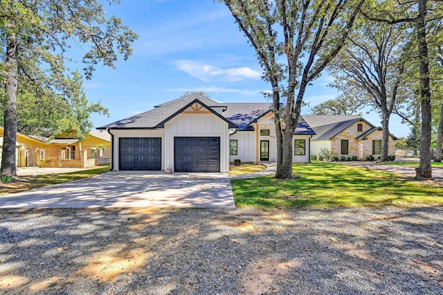 modern inspired farmhouse with a front lawn and a garage