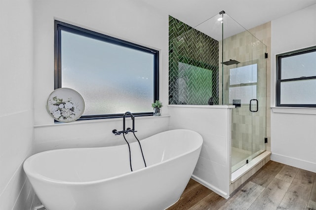 bathroom with a healthy amount of sunlight, plus walk in shower, and wood-type flooring