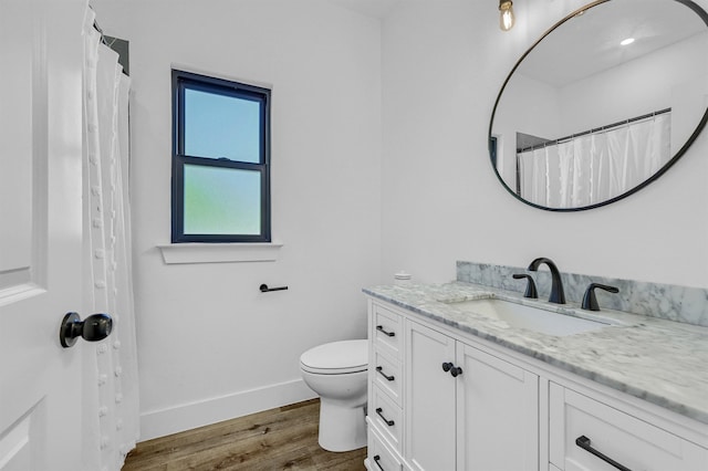 bathroom with toilet, hardwood / wood-style floors, and vanity