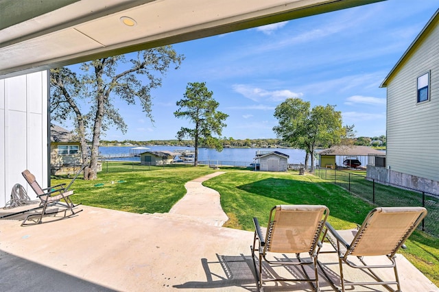 view of patio with a shed and a water view