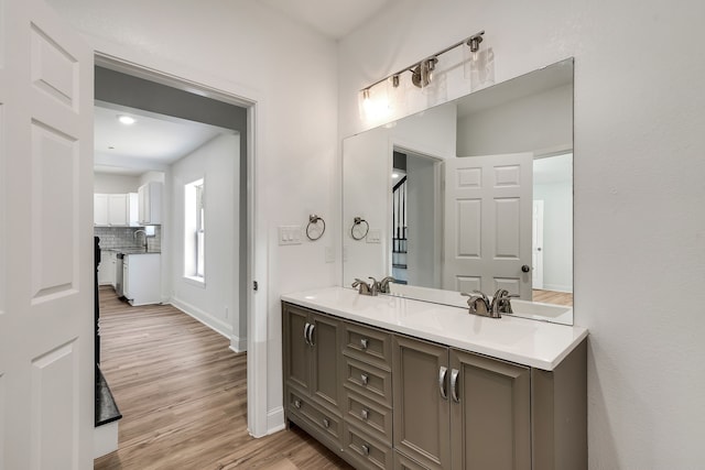 bathroom with decorative backsplash, wood-type flooring, and vanity