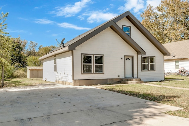 view of front of home featuring a front yard and a storage unit