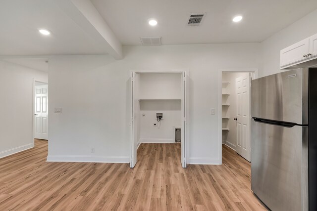 kitchen featuring white cabinets, light wood-type flooring, and stainless steel refrigerator