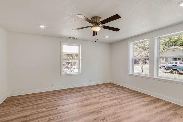 spare room with light hardwood / wood-style flooring, plenty of natural light, and ceiling fan