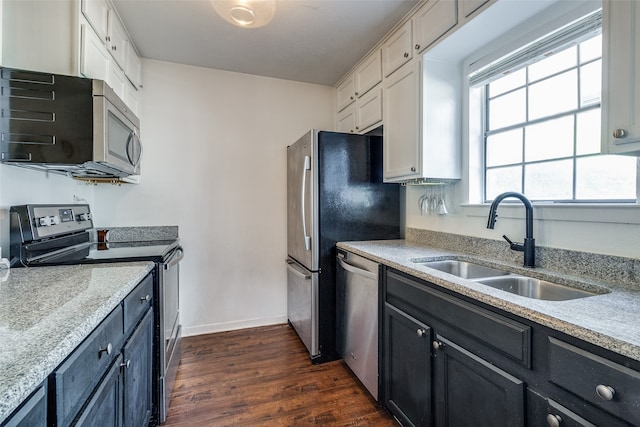 kitchen with appliances with stainless steel finishes, white cabinets, sink, and dark hardwood / wood-style flooring