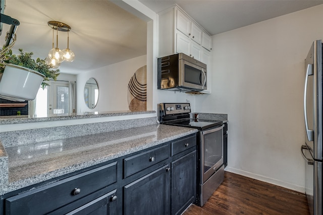 kitchen with dark hardwood / wood-style floors, stainless steel appliances, light stone countertops, decorative light fixtures, and white cabinetry