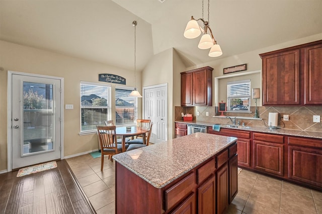 kitchen with decorative light fixtures, a center island, light wood-type flooring, and sink