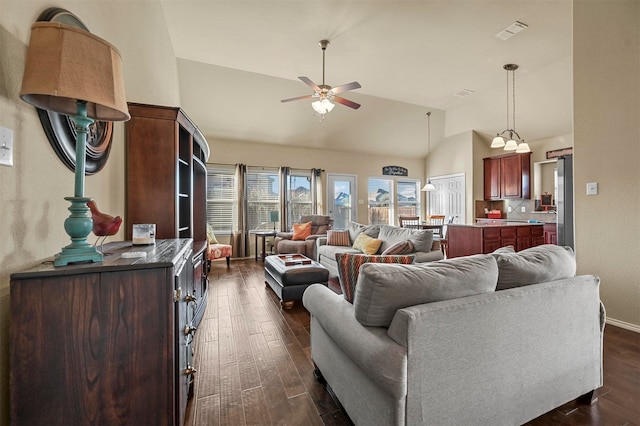 living room with ceiling fan, dark wood-type flooring, and vaulted ceiling