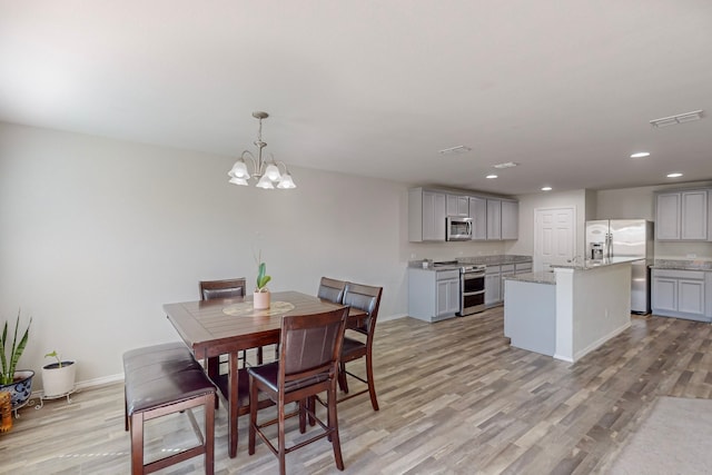 dining room featuring an inviting chandelier and light hardwood / wood-style floors