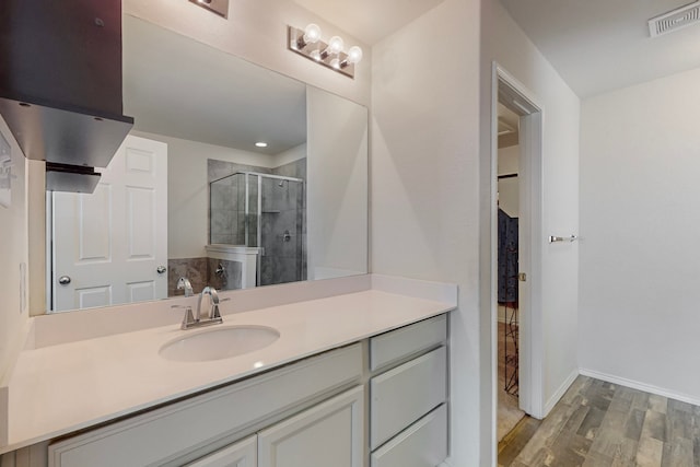 bathroom featuring vanity, wood-type flooring, and a shower with door