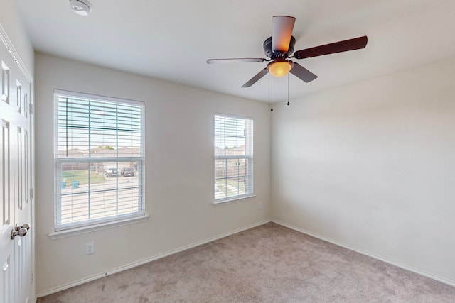 carpeted empty room featuring a wealth of natural light and ceiling fan