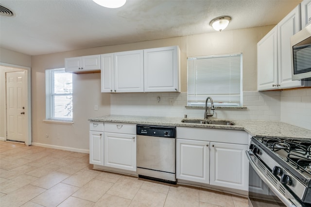 kitchen featuring white cabinetry, backsplash, appliances with stainless steel finishes, and sink