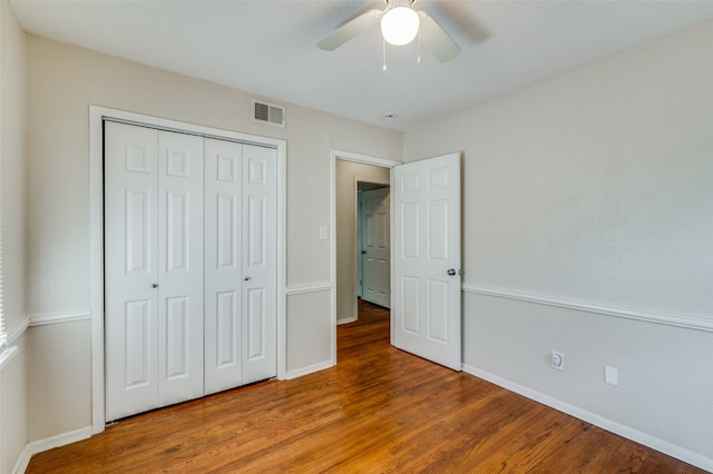 unfurnished bedroom with hardwood / wood-style floors, a closet, and ceiling fan