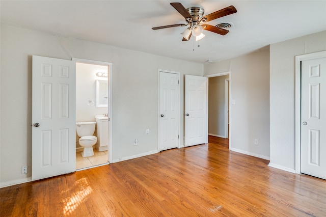 unfurnished bedroom with ensuite bathroom, light wood-type flooring, and ceiling fan