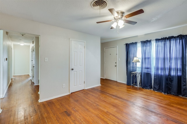 spare room with ceiling fan, a textured ceiling, and hardwood / wood-style floors