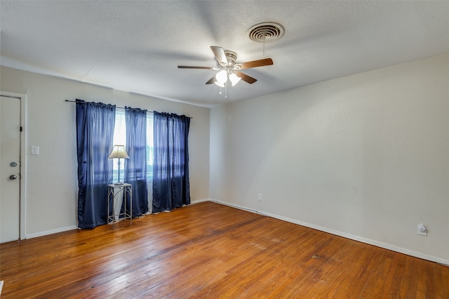 empty room with hardwood / wood-style floors, a textured ceiling, and ceiling fan