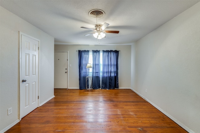 spare room with ceiling fan, wood-type flooring, and a textured ceiling