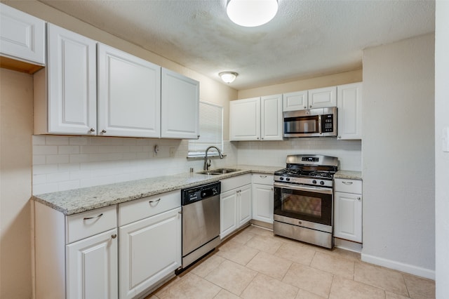 kitchen featuring sink, white cabinets, stainless steel appliances, and backsplash