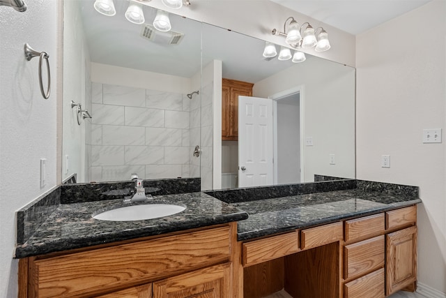 bathroom with vanity and a tile shower