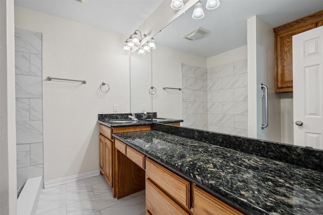 bathroom with tiled shower and vanity