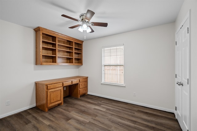 office space with ceiling fan, built in desk, and dark hardwood / wood-style floors