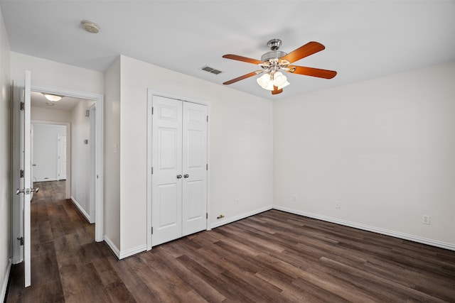 unfurnished bedroom featuring dark wood-type flooring, a closet, and ceiling fan