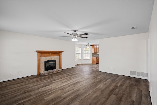 618 W Crawford St, Denison, TX 75020 - unfurnished living room with dark wood finished floors, a ceiling fan, a tile fireplace, and baseboards