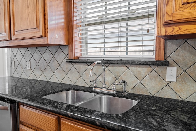 kitchen with dark stone counters, backsplash, sink, and stainless steel dishwasher