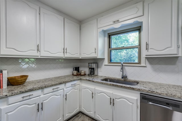 kitchen with dishwasher, a sink, white cabinets, and decorative backsplash