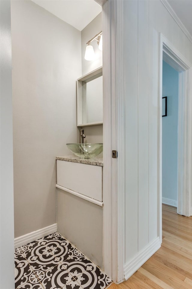 bathroom featuring baseboards, wood finished floors, and vanity