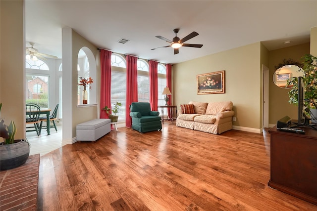 living room featuring wood-type flooring and ceiling fan