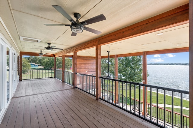 wooden terrace with a water view, ceiling fan, and a yard