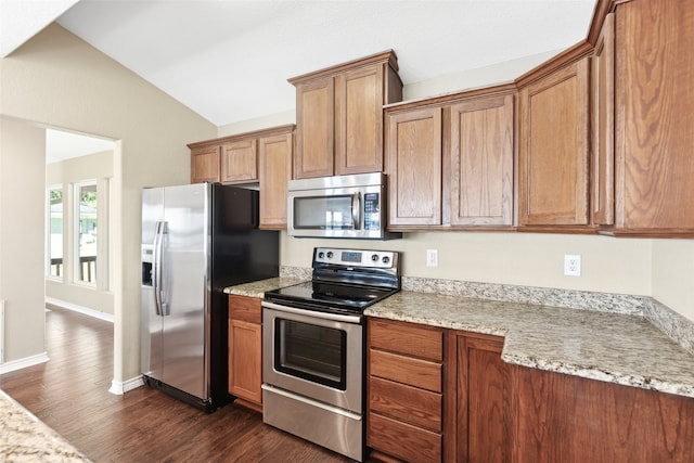 kitchen with light stone countertops, stainless steel appliances, dark wood-type flooring, and vaulted ceiling