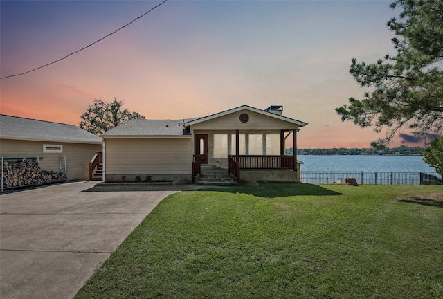 view of front facade featuring a water view and a lawn