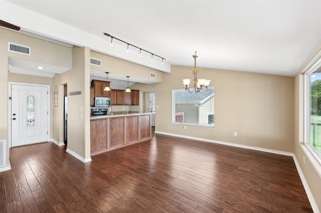 kitchen with an inviting chandelier, a healthy amount of sunlight, decorative light fixtures, and dark wood-type flooring