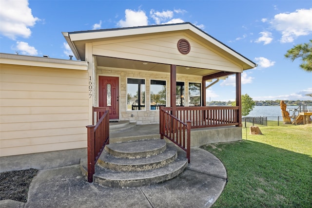 entrance to property with a yard and a water view