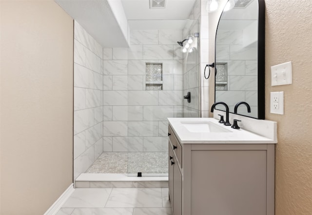 bathroom featuring vanity and tiled shower