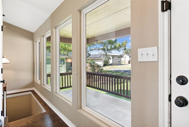 entryway featuring lofted ceiling, hardwood / wood-style floors, and a healthy amount of sunlight