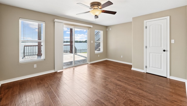16077 Saint Paul Dr, Caney City, TX 75148 - empty room featuring dark wood finished floors, baseboards, ceiling fan, and a water view