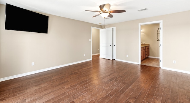 unfurnished bedroom with ensuite bathroom, dark wood-type flooring, and ceiling fan