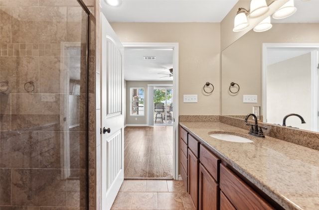 bathroom with vanity, walk in shower, wood-type flooring, and ceiling fan