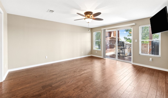 empty room with ceiling fan and dark hardwood / wood-style flooring