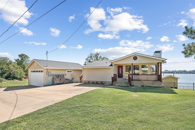 single story home with a water view, covered porch, a front lawn, and a garage