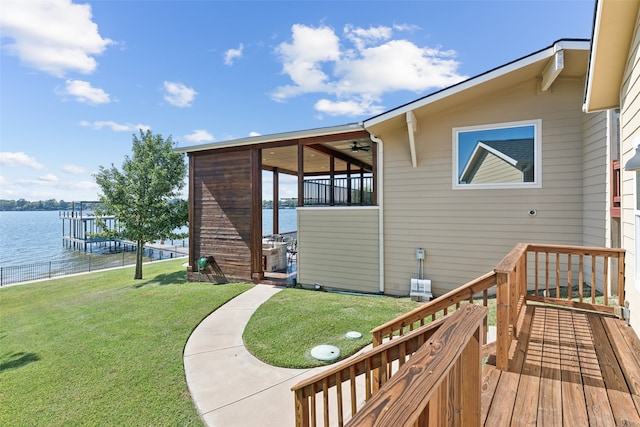 view of side of property featuring a deck with water view and a yard