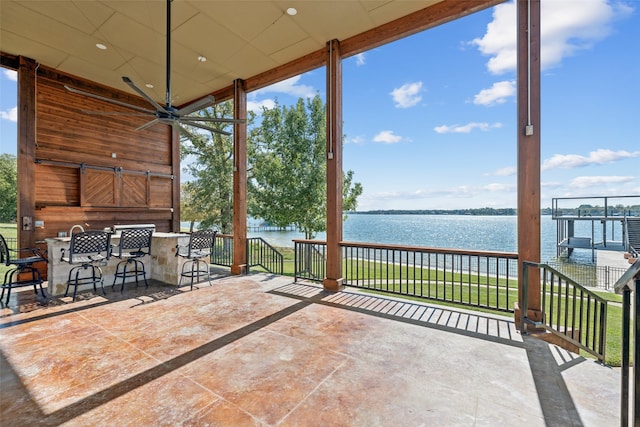 view of patio / terrace featuring a water view and ceiling fan